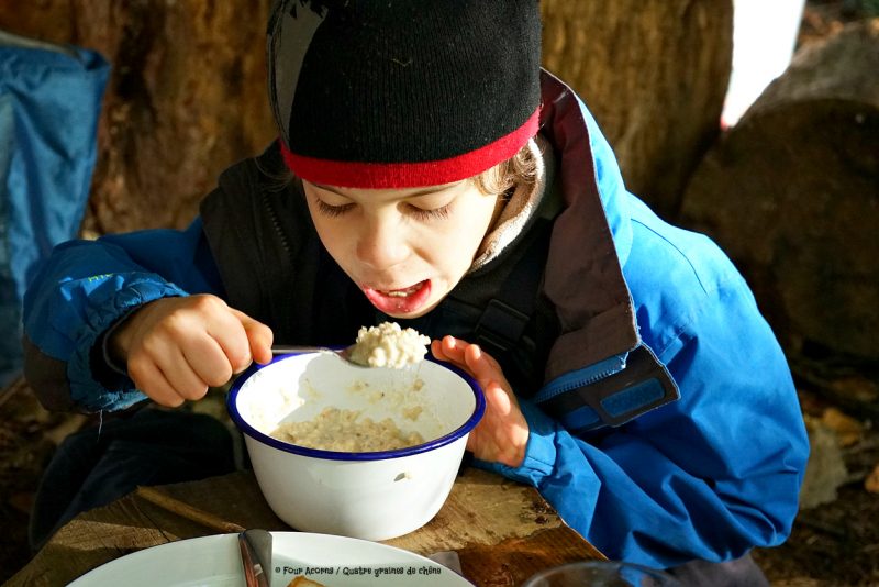 child-eating-porridge-outdoors-falcon-enamel-bowl