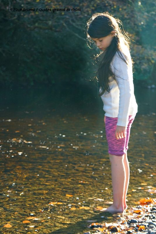 girl-dipping-feet-river-water-sunshine