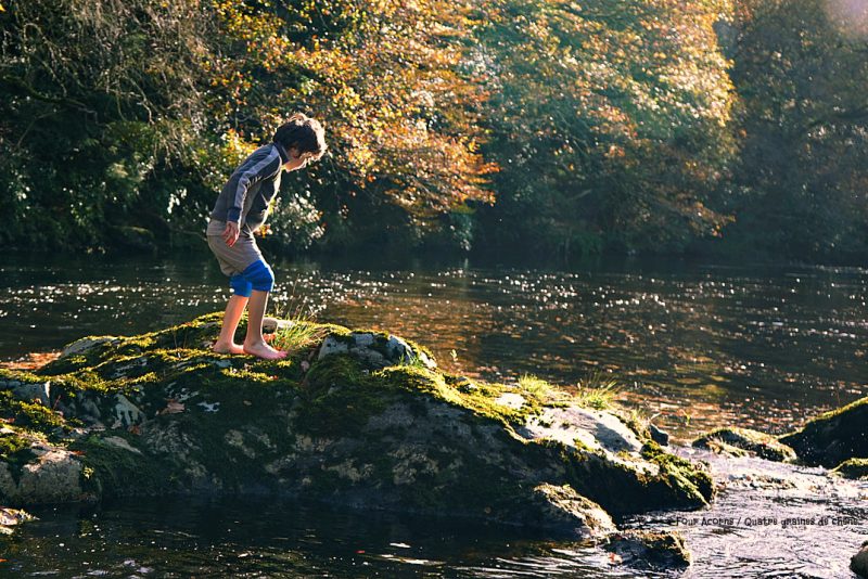 boy-barefoot-rocks-river-autumn-sunshine