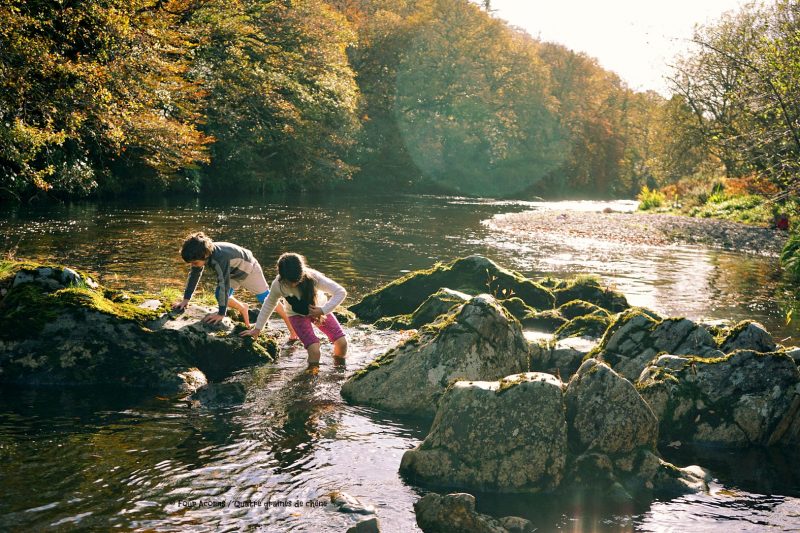 two-children- crossing-river-barefoot-autumn-sunshine