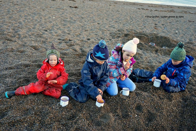 four-children-beach-drinking-hot-chocolate-white-cups