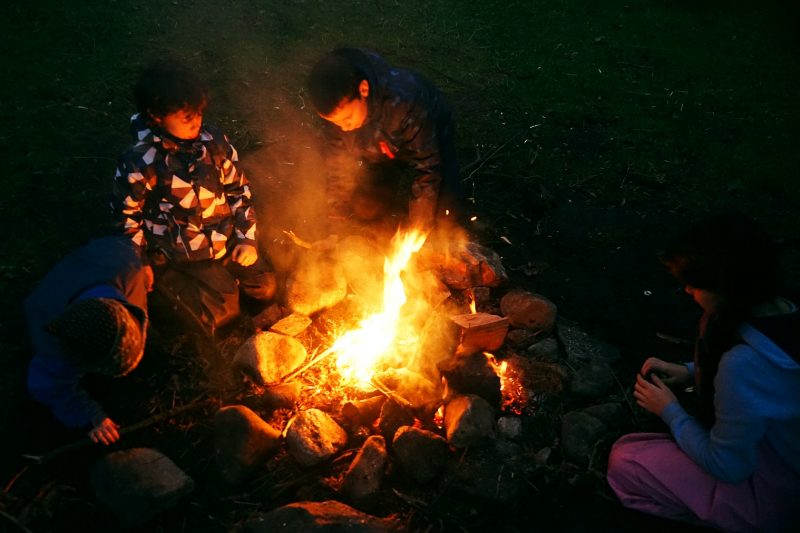four-children-campfire-dark