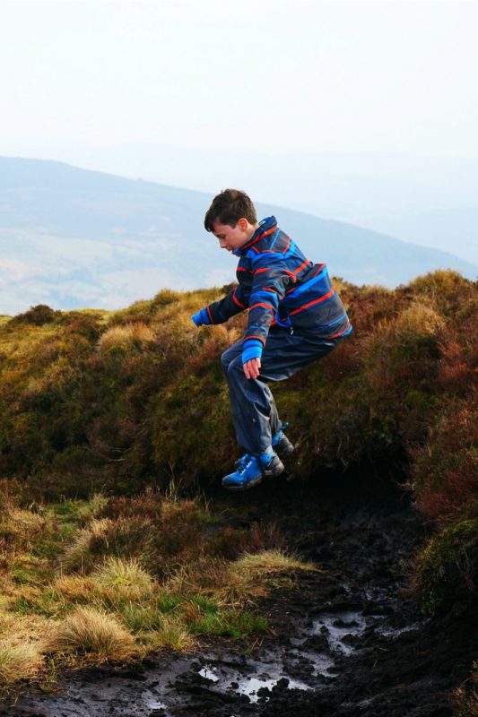 boy-jumps-into-bog-mud-outdoor-fun
