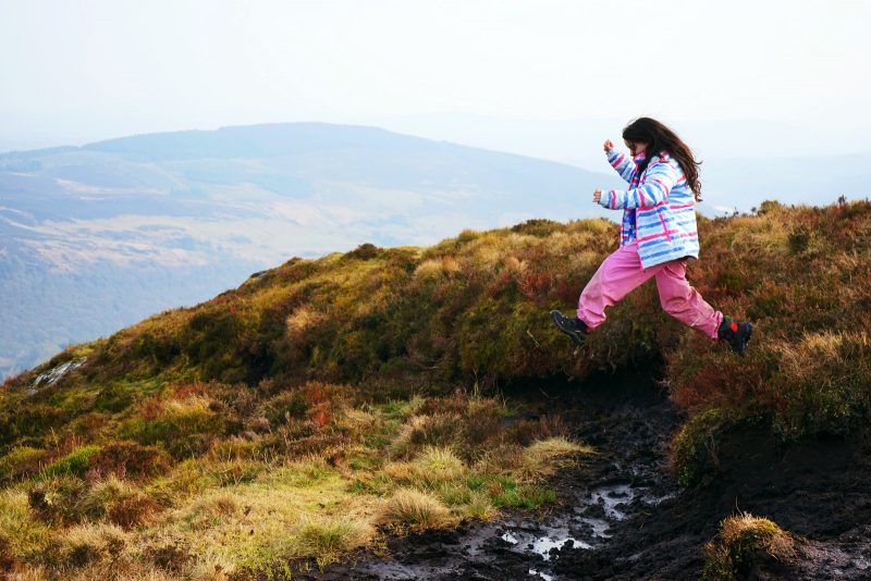 girl-jumps-into-bog-mud-outdoor-fun